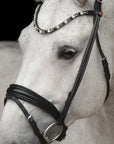 Detailfoto rundgenähte Trense Elli in Schwarz mit Chrombeschlägen am Pferd: konisch geformtes Lack-Reithalfter und Stirnband mit extragroßen Kristallen in Schwarz/Weiß/Grau